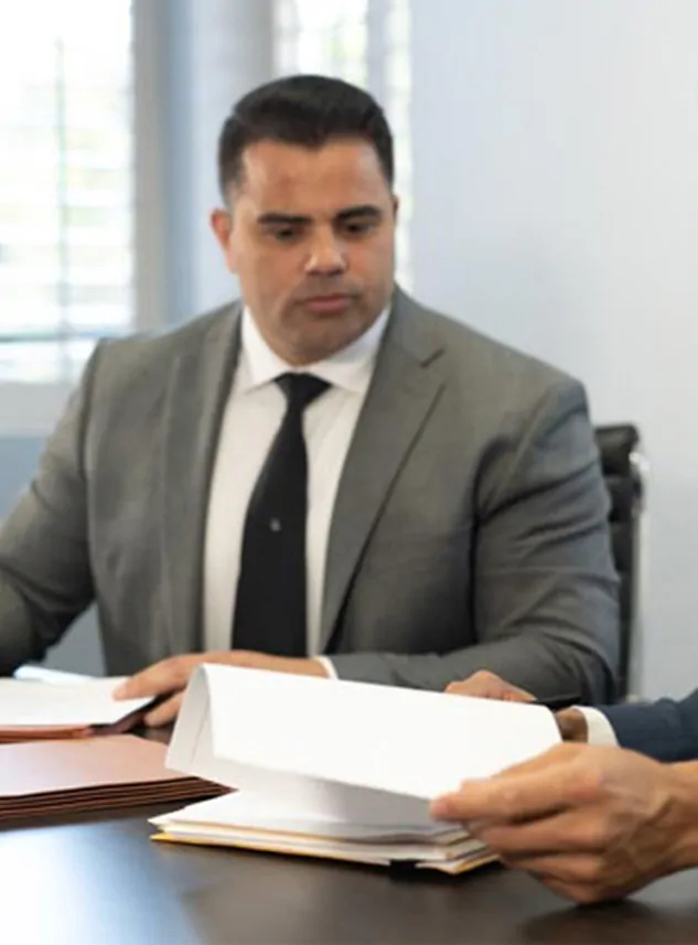 Triumph Curiel reviewing case files at Triumph Law Group