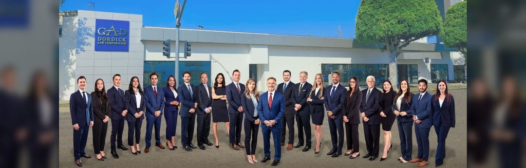 The Dordick Law Corporation team outside the firm's Los Angeles office, the firm name on the building