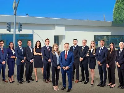 The Dordick Law Corporation team outside the firm's Los Angeles office, the firm name on the building